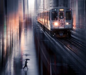 Man walking beneath elevated train